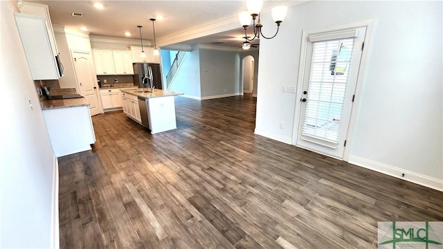 kitchen with pendant lighting, a kitchen island with sink, ornamental molding, white cabinetry, and stainless steel appliances