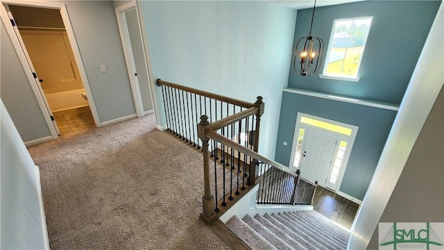 carpeted foyer entrance featuring a chandelier