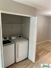 clothes washing area with washing machine and dryer and light colored carpet