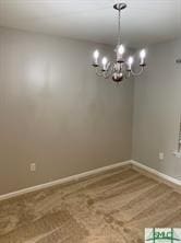 empty room featuring hardwood / wood-style floors and a chandelier