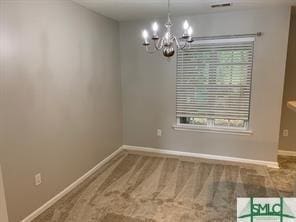 unfurnished dining area featuring carpet and an inviting chandelier