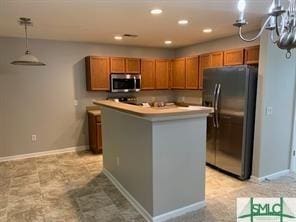 kitchen featuring stainless steel appliances, a kitchen island, and hanging light fixtures