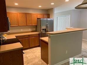 kitchen with a kitchen island, stainless steel fridge with ice dispenser, and range