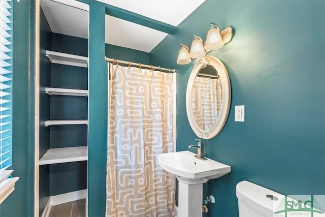 bathroom with tile patterned floors, curtained shower, and toilet