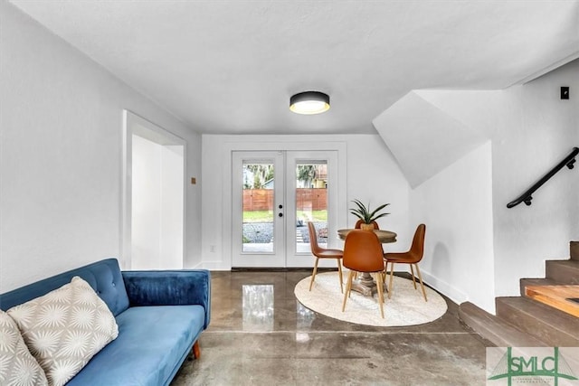 living area featuring french doors and concrete flooring