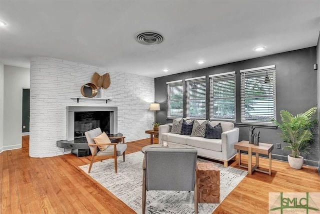 living room with a large fireplace and hardwood / wood-style floors