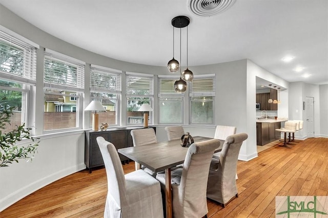 dining room with light hardwood / wood-style floors and sink