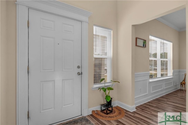 foyer entrance with crown molding and wood-type flooring