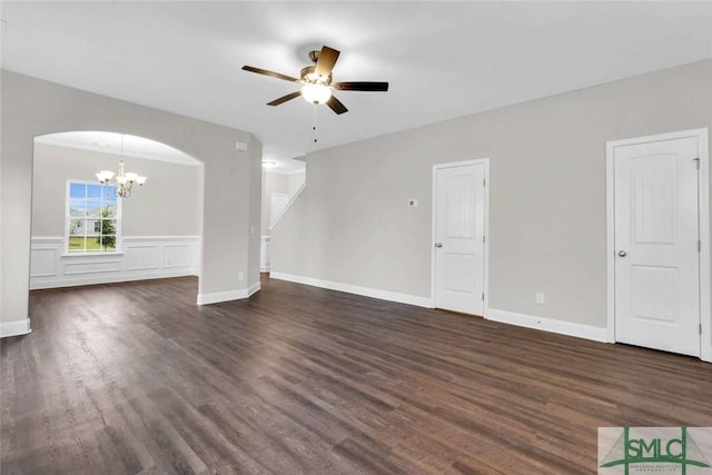 unfurnished living room featuring ceiling fan with notable chandelier and dark wood-type flooring