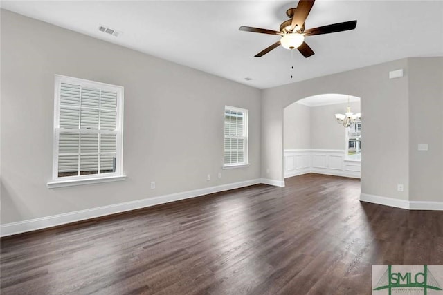 spare room featuring dark hardwood / wood-style flooring and ceiling fan with notable chandelier