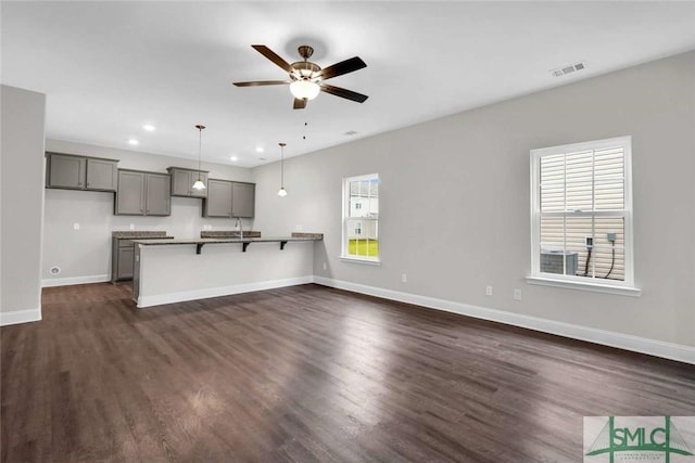 kitchen featuring gray cabinetry, plenty of natural light, hanging light fixtures, and dark hardwood / wood-style floors