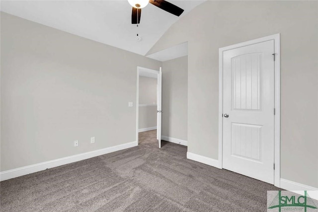 unfurnished bedroom featuring ceiling fan, dark carpet, and lofted ceiling