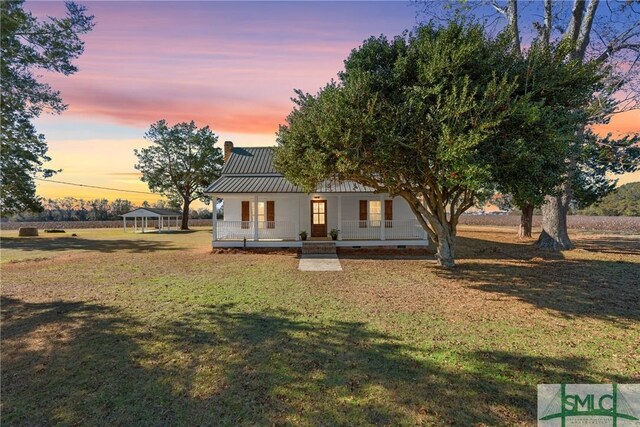 view of front of property with covered porch, a gazebo, and a yard