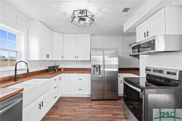 kitchen with wood counters, white cabinets, sink, dark hardwood / wood-style floors, and appliances with stainless steel finishes