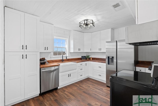 kitchen with white cabinetry, dark wood-type flooring, stainless steel appliances, and wood counters