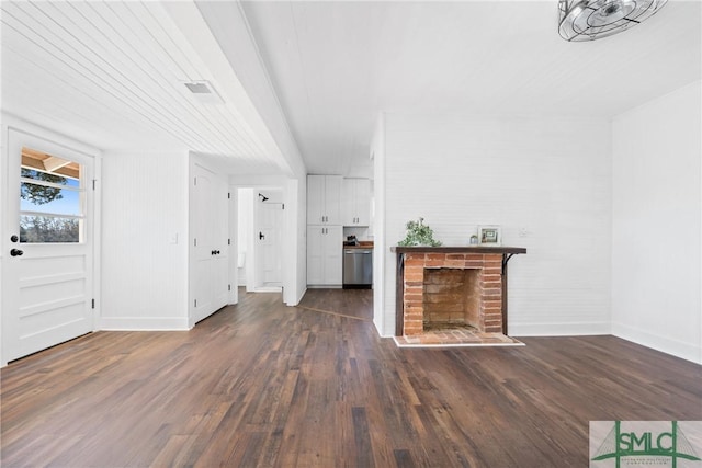 unfurnished living room with dark hardwood / wood-style flooring and a brick fireplace