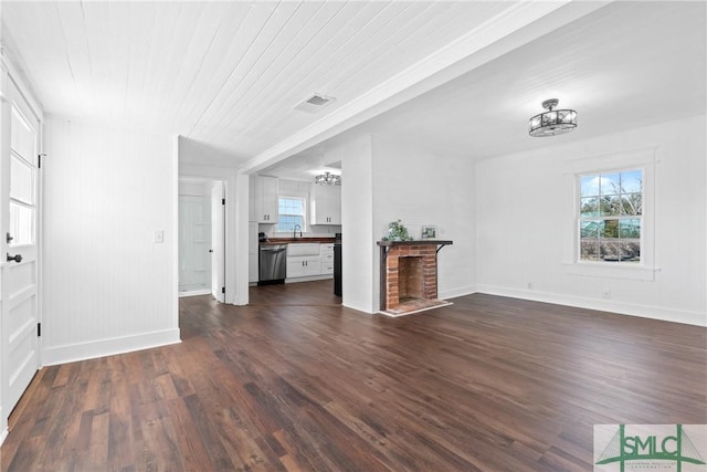 unfurnished living room with dark hardwood / wood-style floors, plenty of natural light, and a fireplace