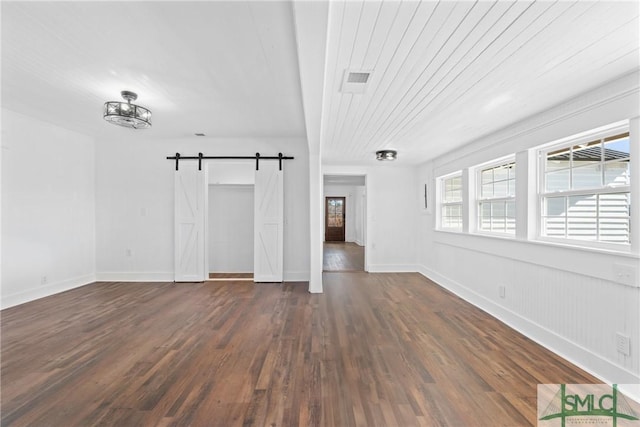 interior space with a barn door and dark wood-type flooring