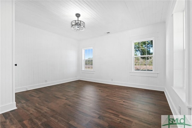 unfurnished room with dark wood-type flooring and an inviting chandelier