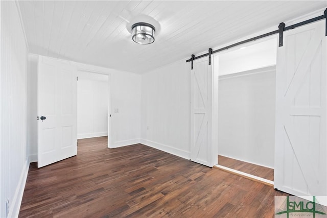 interior space featuring a barn door and dark wood-type flooring