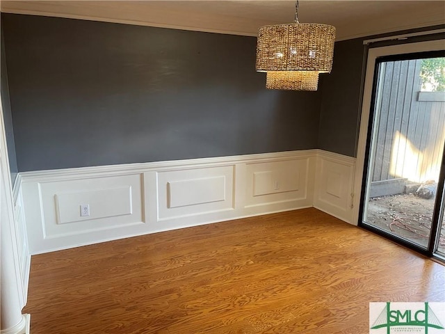 spare room featuring a chandelier and hardwood / wood-style flooring