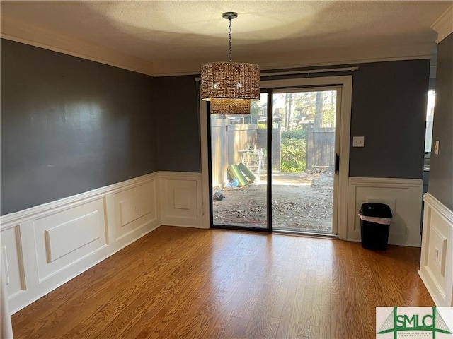 unfurnished dining area with hardwood / wood-style flooring and ornamental molding