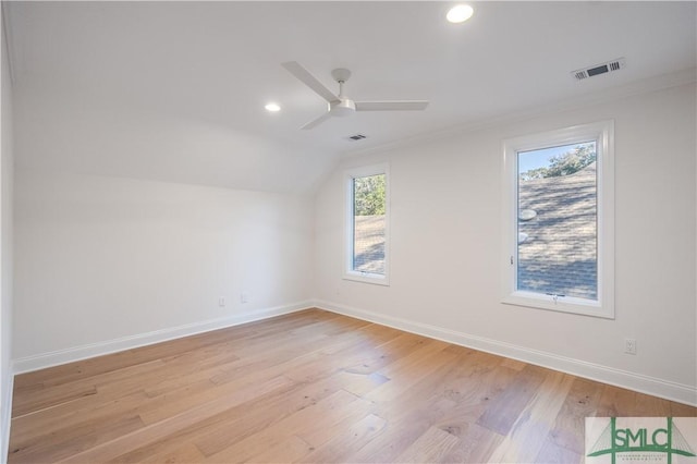 unfurnished room featuring ceiling fan, crown molding, vaulted ceiling, and light wood-type flooring