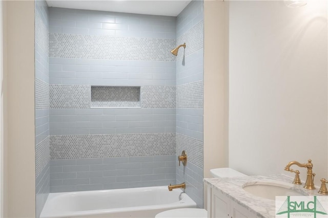 full bathroom featuring tiled shower / bath combo, toilet, and vanity