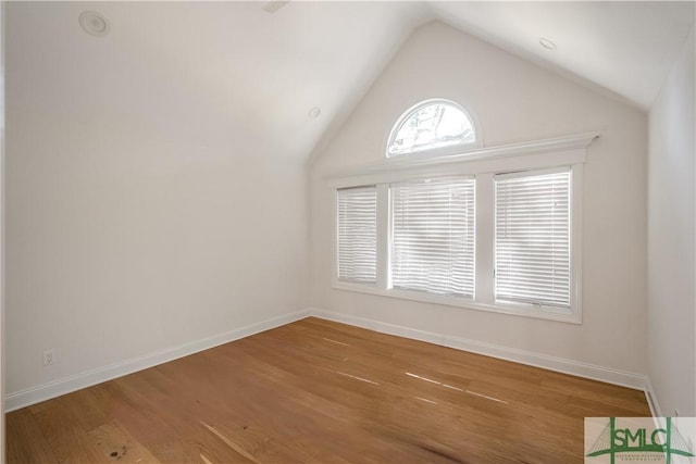 empty room featuring hardwood / wood-style floors and vaulted ceiling