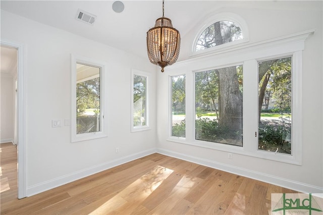 unfurnished sunroom with a wealth of natural light and a chandelier