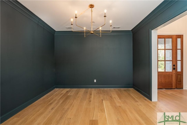 unfurnished room featuring a chandelier, light hardwood / wood-style floors, and ornamental molding