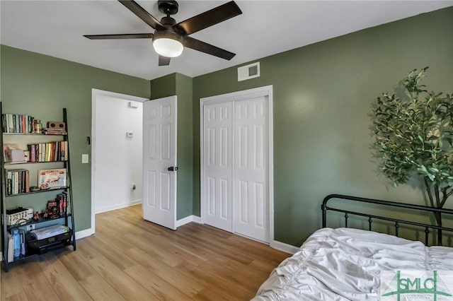 bedroom with light wood-type flooring, a closet, and ceiling fan