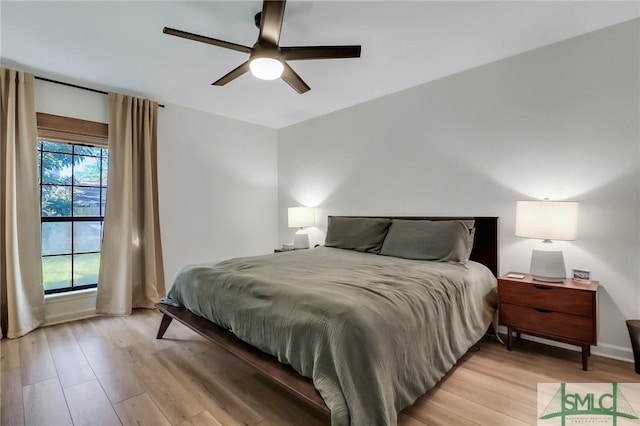 bedroom with multiple windows, ceiling fan, and light hardwood / wood-style floors