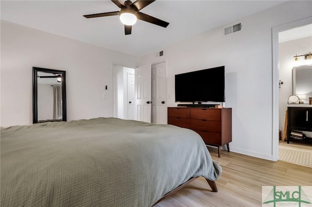 bedroom featuring light hardwood / wood-style floors, ensuite bath, and ceiling fan