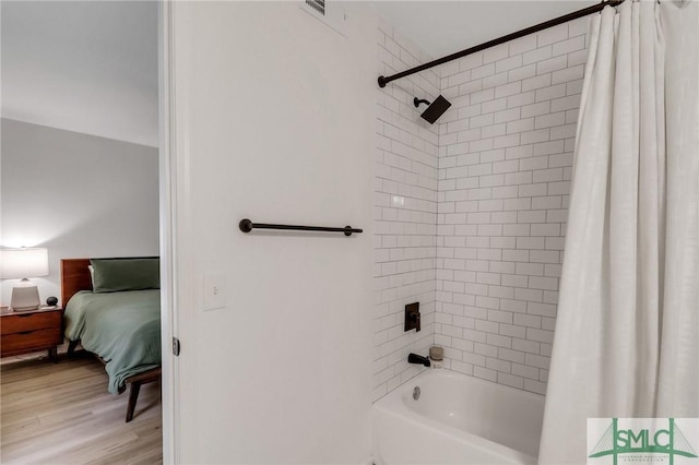 bathroom featuring hardwood / wood-style floors and shower / bath combo with shower curtain