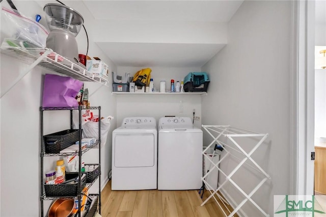 laundry area featuring light hardwood / wood-style floors and washing machine and clothes dryer