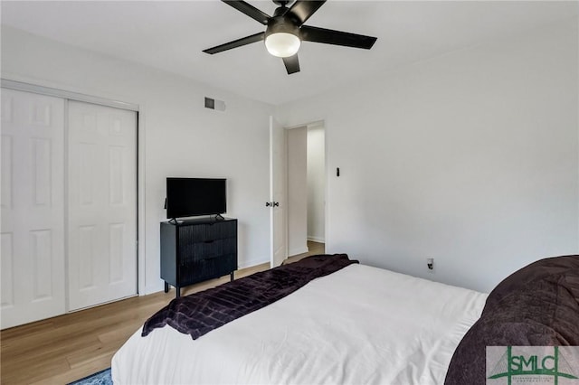 bedroom featuring ceiling fan, light wood-type flooring, and a closet