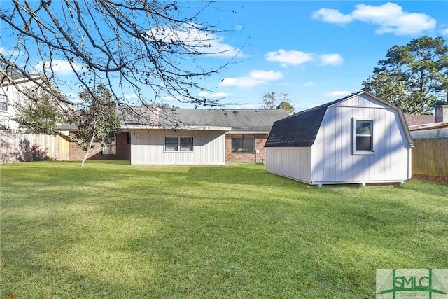 rear view of property with a yard and a shed