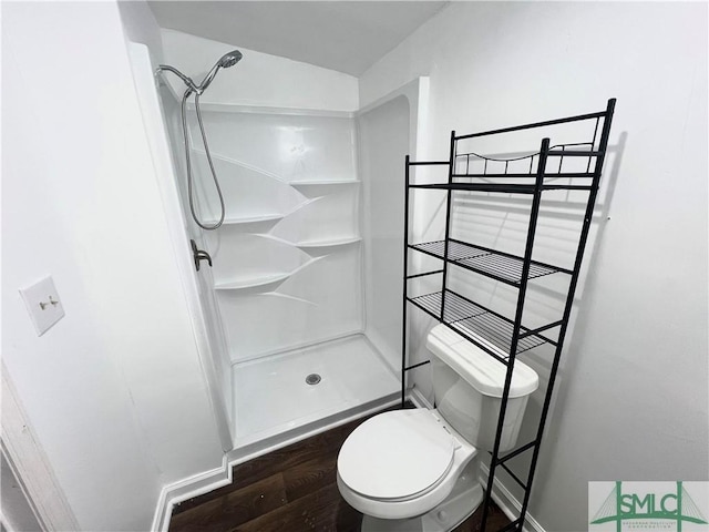 bathroom featuring hardwood / wood-style flooring, toilet, and a shower