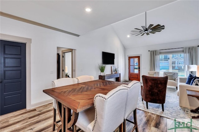 dining space with hardwood / wood-style flooring, ceiling fan, and vaulted ceiling