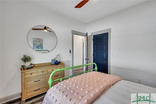 bedroom with dark hardwood / wood-style flooring and ceiling fan