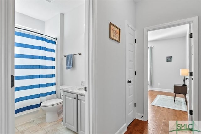 bathroom with a shower with curtain, hardwood / wood-style floors, vanity, and toilet