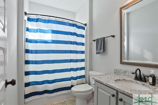 bathroom featuring tile patterned flooring, vanity, toilet, and walk in shower