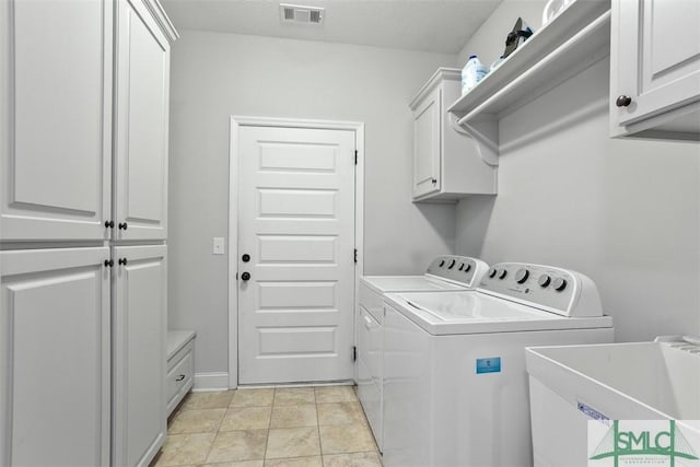 laundry area with cabinets, light tile patterned floors, separate washer and dryer, and sink