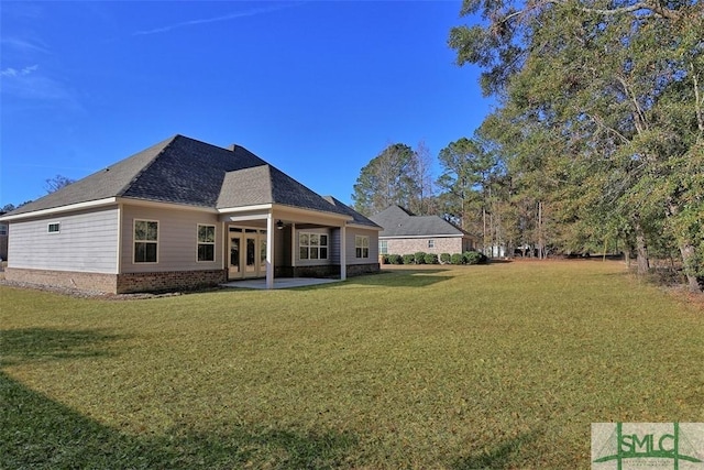 rear view of property with a yard and a patio