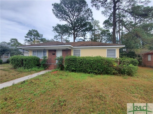 view of front of home featuring brick siding and a front yard