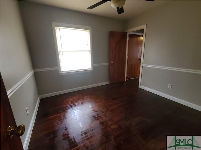 spare room with ceiling fan and dark wood-type flooring