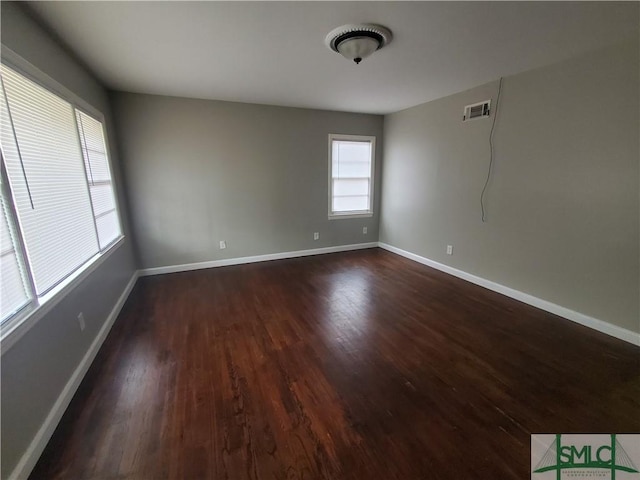 unfurnished room with dark wood-type flooring