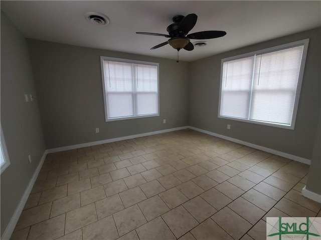 spare room featuring a wealth of natural light, light tile patterned floors, and ceiling fan