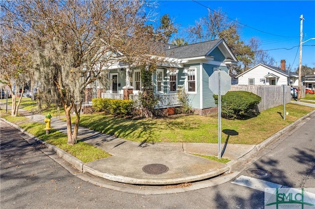 bungalow-style home with a front yard and covered porch